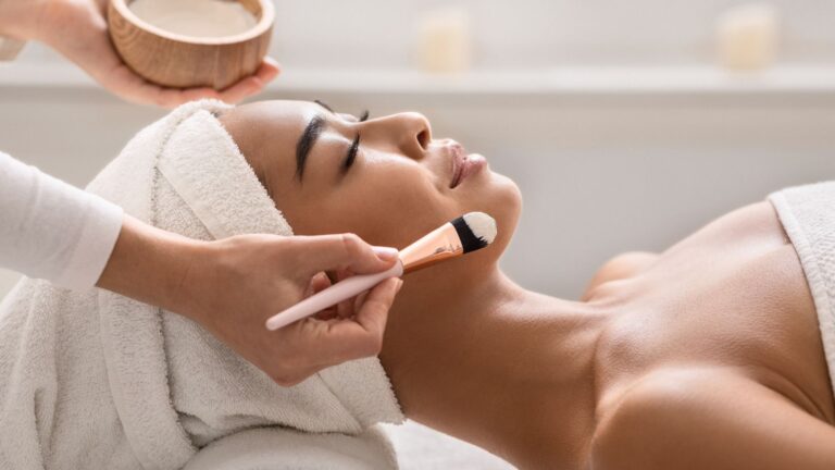 image showing a beauty therapist applying a face mask to a woman in a spa