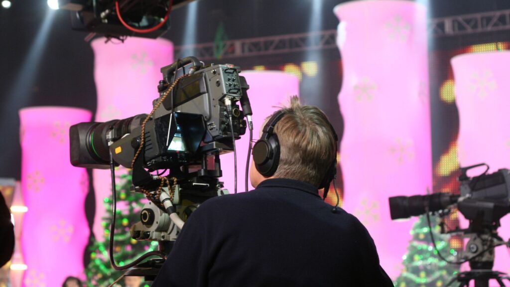 image showing a camera operator standing behind a camera