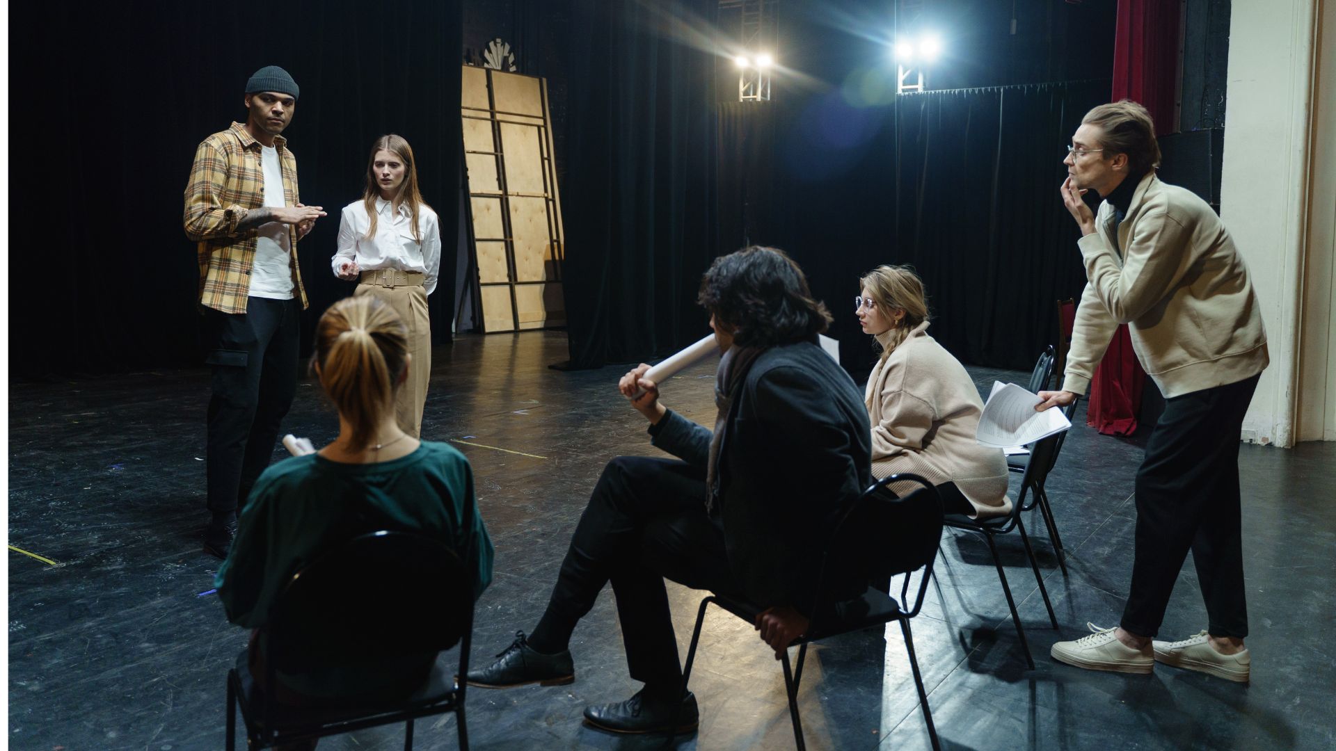 image showing a casting director sitting in a theater speaking with actors and actresses