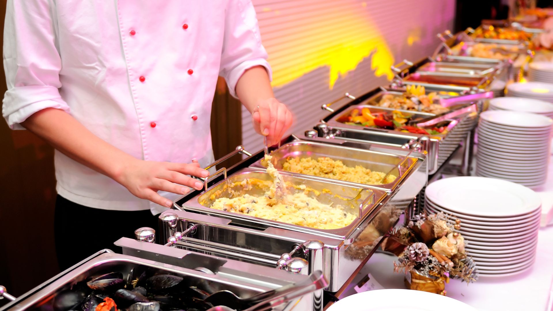 image showing a chef de partie at a food station serving food to guests