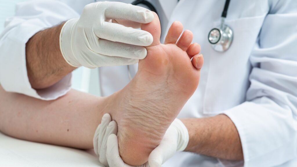image showing a chiropodist working on the toe of a patient's foot