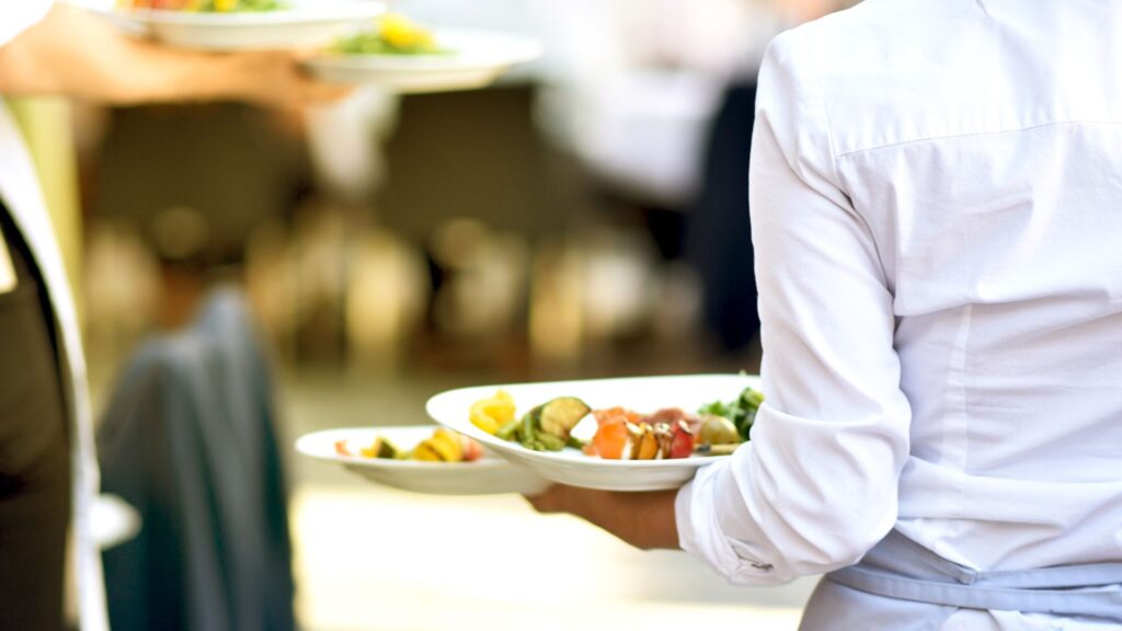 image showing a waiting staff member carrying food to a table